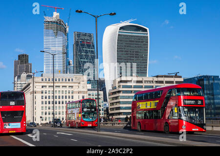 London, UK, 28. Januar 2019: Drei roten Londoner Busse Überqueren der historischen London Bridge mit der modernen Wolkenkratzer der Stadt London in der Ba Stockfoto