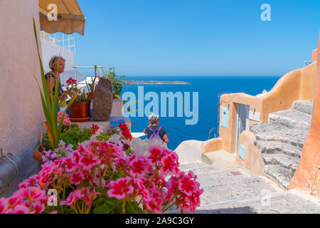 Oia, Santorini, Griechenland - 7. August 2019; Blick auf Mittelmeer von h] illside Häuser und Gebäude in Weiß getünchten mit Farbtupfern in traditio Stockfoto