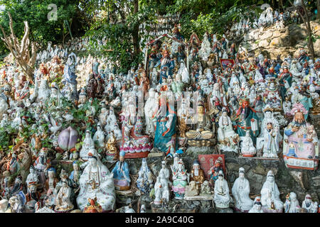 Hunderte von kleinen Statuen, die Götter der verschiedenen Religionen an einem Hügel in einem Coastal Park im Waterfall Bay, Hong Kong sitzen. Stockfoto