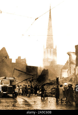 WWII - ein Bus als ein Krankenwagen benutzt wird nach dem verheerenden Bombenangriff auf Coventry UK 1941 (Coventry Blitz). Kirche der Heiligen Dreifaltigkeit erhebt sich über eine Szene der totalen Zerstörung. Stockfoto