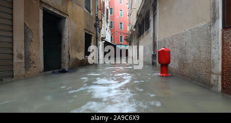 Rote Hydrant auf dem überschwemmten Gasse in Venedig in Italien während der Flut, Stockfoto