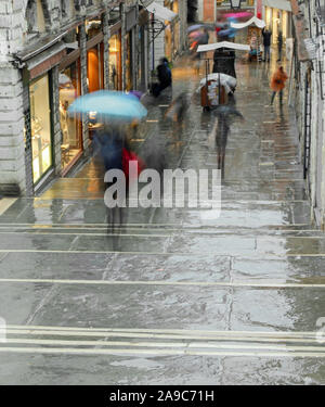 Menschen auf der Rialtobrücke in Venedig Italien mit Sonnenschirmen bei Regen Stockfoto