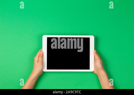 Kind Hände halten Tablet Computer auf hellgrüner Hintergrund Stockfoto