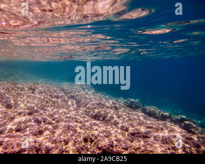 Unterwasser Meereslandschaft mit flachen felsigen Meeresgrund auf reflektierende Oberfläche Stockfoto