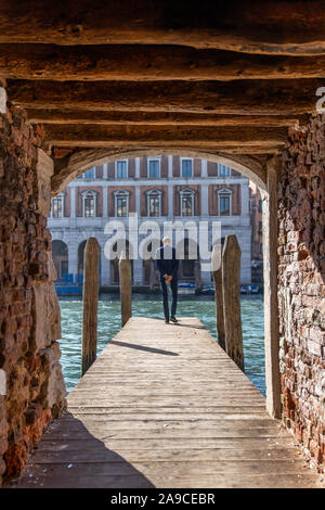 Man Walking auf Holz Pier in Venedig, Italien Stockfoto