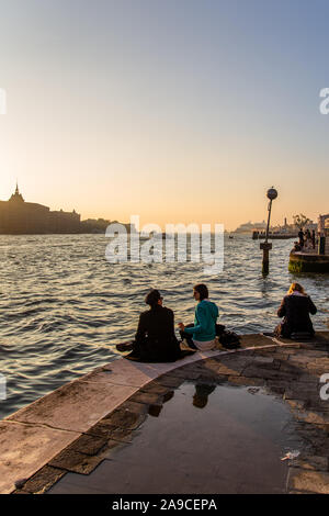 Paar beobachten Sonnenuntergang über Kanal in Venedig Venezia, Italien Stockfoto