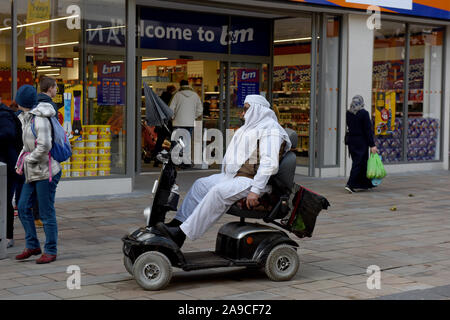 Wolverhampton, Großbritannien, Großbritannien Street Fotografie Menschen auf Mobilität scooter tragen im arabischen Stil Kleidung Stockfoto