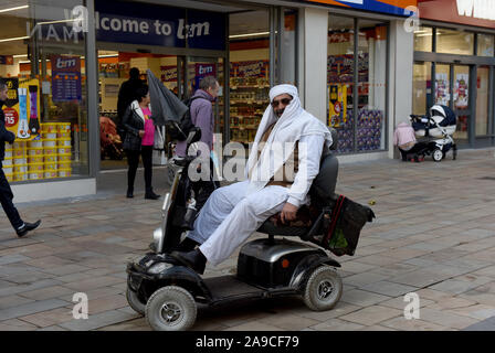 Wolverhampton, Großbritannien, Großbritannien Street Fotografie Menschen auf Mobilität scooter tragen im arabischen Stil Kleidung Stockfoto