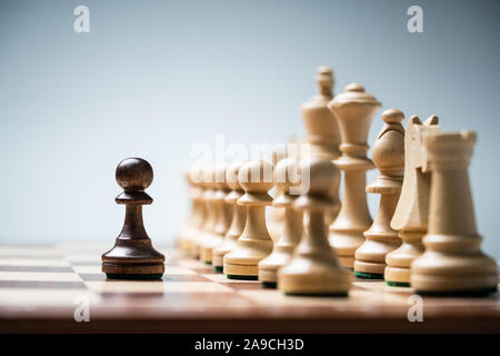 Reihe der Schachfiguren an Bord vor blauem Hintergrund Stockfoto