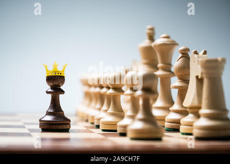 Reihe der Schachfiguren an Bord vor blauem Hintergrund Stockfoto