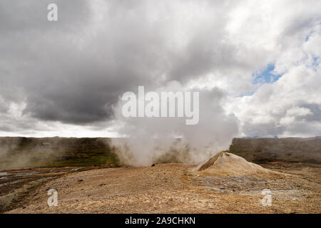 Vulkanische Landschaft mit einer großen Fumarole strahlt, dass viel Dampf, kontrastierende Himmel mit einem kleinen blauen sowie weiße und graue Wolken - Ort: Ic Stockfoto