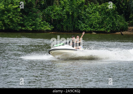 Glückliches junges Paar mit Daumen nach oben genießen und Spaß reiten auf einem Jet Ski. Tropischen Küste von Sri Lanka Stockfoto