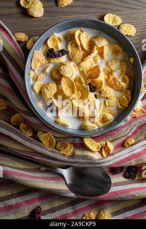 Frühstück. Cornflakes mit Milch und getrockneten Beeren. Stockfoto