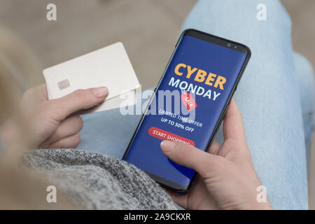 Mädchen mit einem Handy in der Hand macht Einkäufe auf der Cyber Monday online. Schnelle und einfache Trading Konzept. Stockfoto