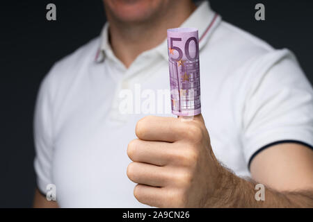 Den mittleren Abschnitt in eines Mannes Hand, rollte bis 500 Euro Notizen über seinen Daumen Stockfoto