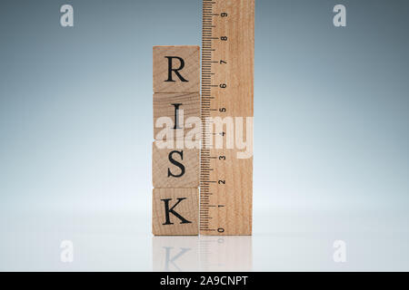 Risiko Wort auf Holzblöcken gestapelt in der Nähe des Herrschers auf reflektierenden Schreibtisch Stockfoto