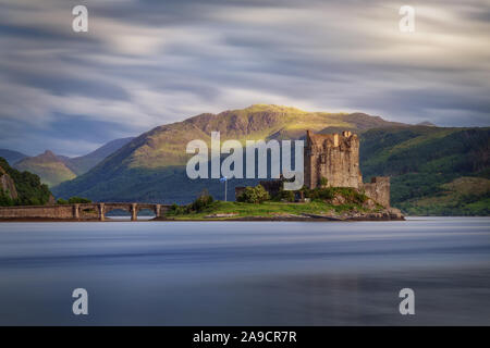 Eilean Donan Castle, eine schottische Schloss auf der Insel durch eine Brücke in ein Loch verbunden. Schottland Highlands. Bewölkten Tag, langen Belichtungszeit. Stockfoto