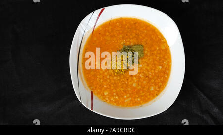 Rote Linsensuppe auf dem schwarzen Hintergrund Stockfoto