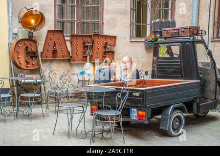 Zwei blonde Haare Mädchen trinken an der Tabelle in ein gemütliches Cafe in der Altstadt von Riga, Lettland Stockfoto