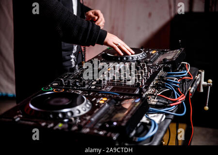 DJ spielt live und Mischen von Musik auf Drehsockel Konsole im Stadium der Night Club. Disk Jokey Hände auf einem Mischpult Station im Club Party. DJ-Mixer Stockfoto