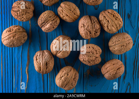 Ansicht von oben Foto von ganze Walnüsse auf Blau lackiert Holztisch in der Schüssel Stockfoto