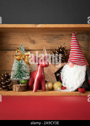 Weihnachtsdekoration Rotwild Abbildung und gnome in einer Holzkiste Hintergrund Stockfoto