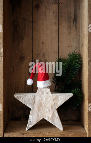 Weihnachtsdekoration Weihnachtsmann Hut auf einem Stern in einer Holzkiste Hintergrund Stockfoto