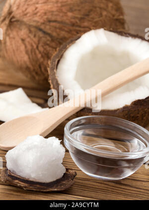 Kokosnuss und Öl gegen Holz- Hintergrund Stockfoto
