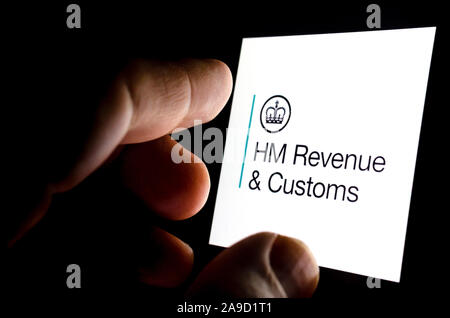 HMRC app Logo auf einem leuchtenden Bildschirm des Smartphones und die Finger berühren. Konzeptionelle Foto für die Interaktion der Bürger und der Kontakt mit HMRC. Stockfoto