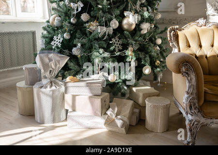 Viele Weihnachten Geschenke unter dem Baum mit Verzierungen. Weihnachten Kugeln, Schleife, Schneeflocken, Tannenzapfen und Leuchten. Stockfoto