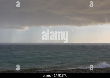 Niedrige düstere Wolken über dem Meer hängenden, starker Regen und der bevorstehenden Tornado an einem Sommertag. Stockfoto