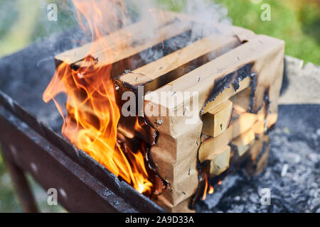 Innovative effiziente Brennholz in Form eines Würfels von Holzbalken brennen für ein Barbecue. Stockfoto