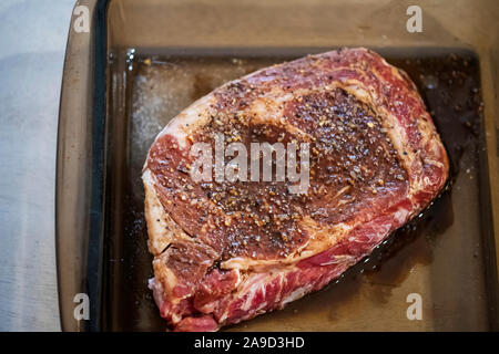 Eine raw-Rib Eye Steak marinieren für Geschmack und Zartheit vor dem Kochen. Nach unten schauen. USA. Stockfoto