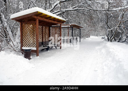Winterlandschaft mit Laufsteg in den verschneiten Park und die Bänke in den Pavillons für Entspannung perspektivische Ansicht Stockfoto