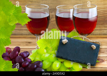 Rotwein mit Trauben und Label Stockfoto