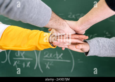 Studenten, die Hände an die Hochschule mit einer Tafel im Hintergrund. Stockfoto