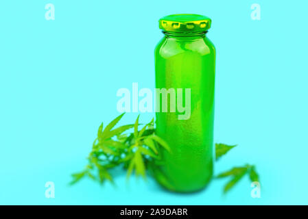 Cannabis CBD Smoothie in grünem Glas Saft Flasche auf Blau, medizinisches Marihuana Konzept isoliert Stockfoto