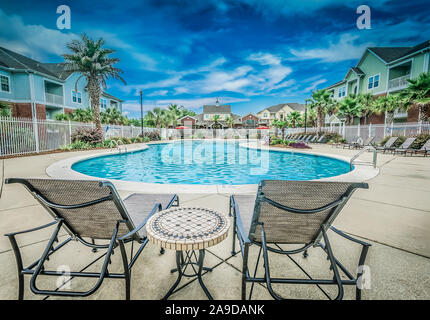 Liegestühle mit Blick auf den Pool im Cypress Cove Apartment Wohnungen in Mobile, Alabama. Der Apartmentkomplex ist im Besitz von Sealy betrieben. Stockfoto