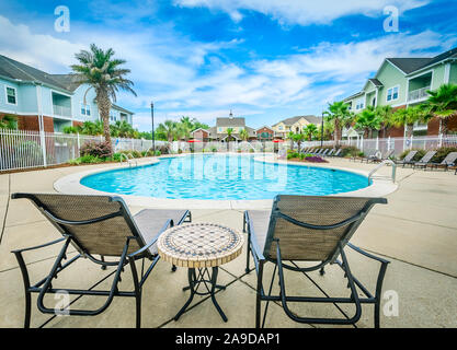 Liegestühle mit Blick auf den Pool im Cypress Cove Apartment Wohnungen in Mobile, Alabama. Der Apartmentkomplex ist im Besitz von Sealy betrieben. Stockfoto