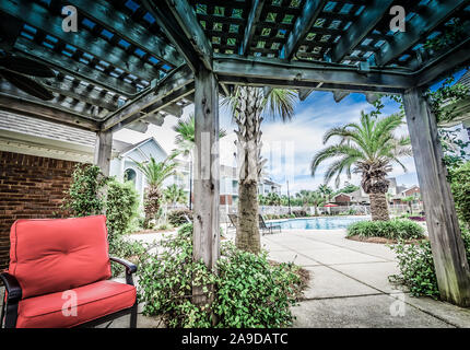 Plüsch Kissen sorgen eine gemütliche Sitzecke unter der hölzernen Pergola Terrasse Abdeckung am Cypress Cove Apartment Wohnungen in Mobile, Alabama. Stockfoto