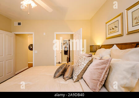 Ein Hauptschlafzimmer mit Badezimmer wird dargestellt im Cypress Cove Apartment Wohnungen in Mobile, Alabama. Stockfoto