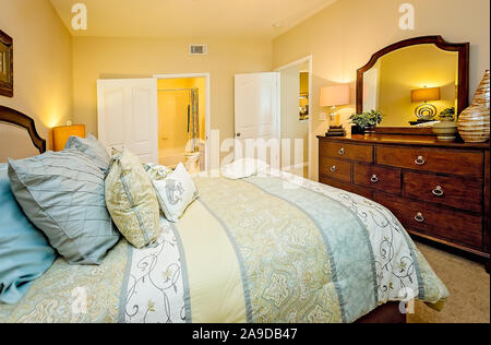 Ein Hauptschlafzimmer mit Badezimmer wird dargestellt im Cypress Cove Apartment Wohnungen in Mobile, Alabama. Stockfoto