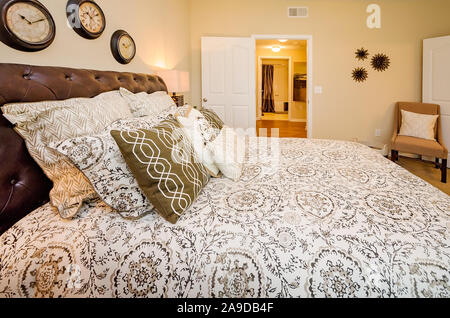 Ein Hauptschlafzimmer mit Badezimmer wird dargestellt im Cypress Cove Apartment Wohnungen in Mobile, Alabama. Stockfoto