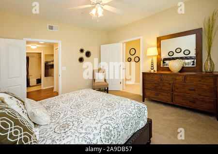 Ein Hauptschlafzimmer mit Badezimmer wird dargestellt im Cypress Cove Apartment Wohnungen in Mobile, Alabama. Stockfoto