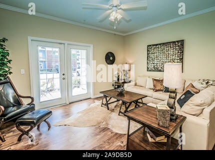 Das Wohnzimmer verfügt über französische Türen, die auf dem Balkon oder der Terrasse am Cypress Cove Apartment Wohnungen in Mobile, Alabama. Stockfoto