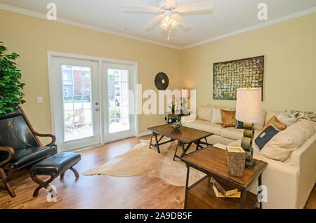 Das Wohnzimmer verfügt über französische Türen, die auf dem Balkon oder der Terrasse am Cypress Cove Apartment Wohnungen in Mobile, Alabama. Stockfoto