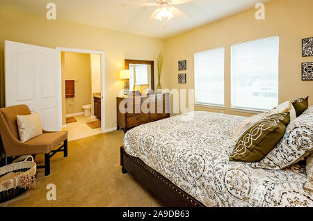 Ein Hauptschlafzimmer mit Badezimmer wird dargestellt im Cypress Cove Apartment Wohnungen in Mobile, Alabama. Stockfoto