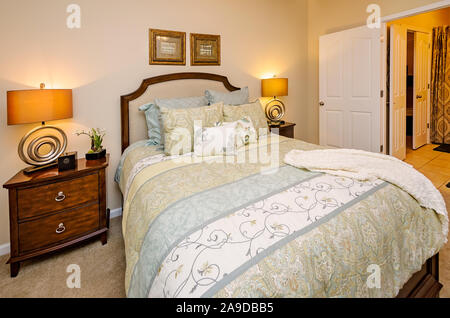 Ein Hauptschlafzimmer mit Badezimmer wird dargestellt im Cypress Cove Apartment Wohnungen in Mobile, Alabama. Stockfoto