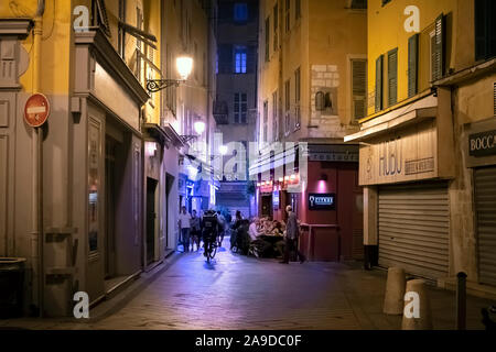 Ein uber isst Fahrrad Delivery Man reitet Vergangenheit ein straßencafe spät in der Nacht als er das Essen zu einem Ziel im Zentrum der Altstadt von Nizza, Frankreich trägt. Stockfoto