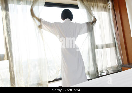 Die junge Frau in einem Hotelzimmer für Kaffee Stockfoto